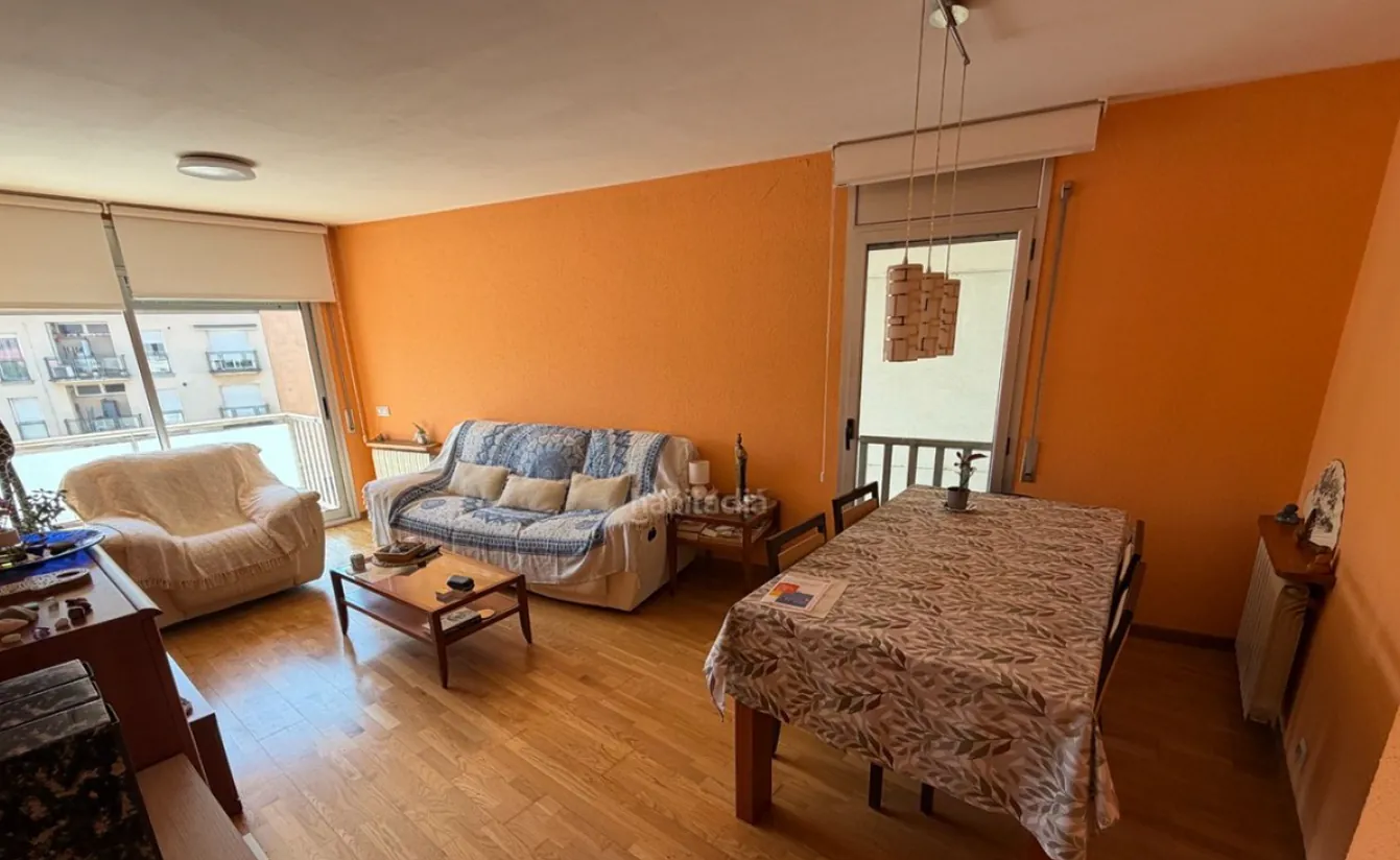 Avant&nbsp;: le même salon, avec un mur orange, des meubles personnels et de nombreux objets